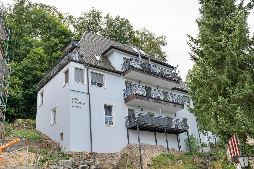 a white house with balconies on a hill at Haus Burgblick in Badenweiler