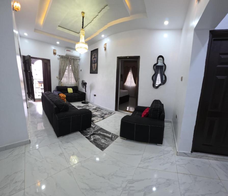 a living room with two black couches and a fireplace at MDY Apartments in Ile-Ife