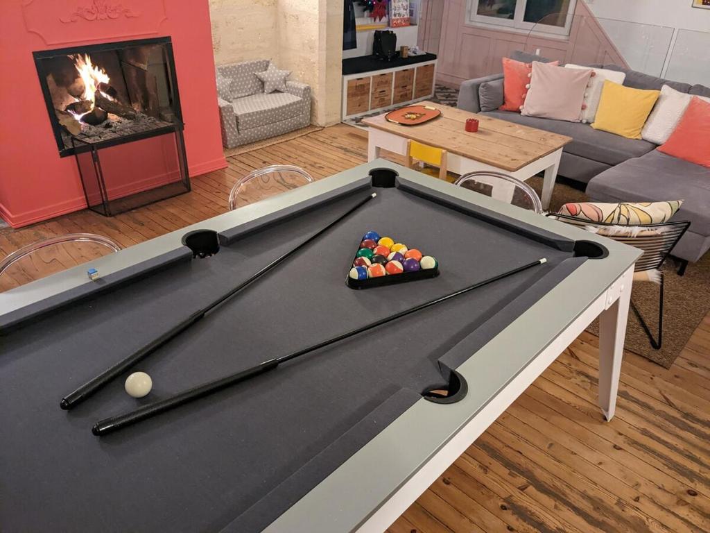 a billiard table in a living room with a fireplace at 1860 Bordeaux - Lormont house in Lormont