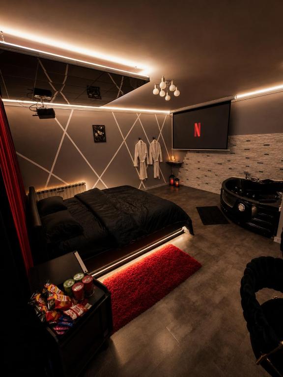 a bedroom with a bed and a tv on the wall at Suite O'Dream - Jacuzzi - Cinéma - Climatisation in Fleury-les-Aubrais