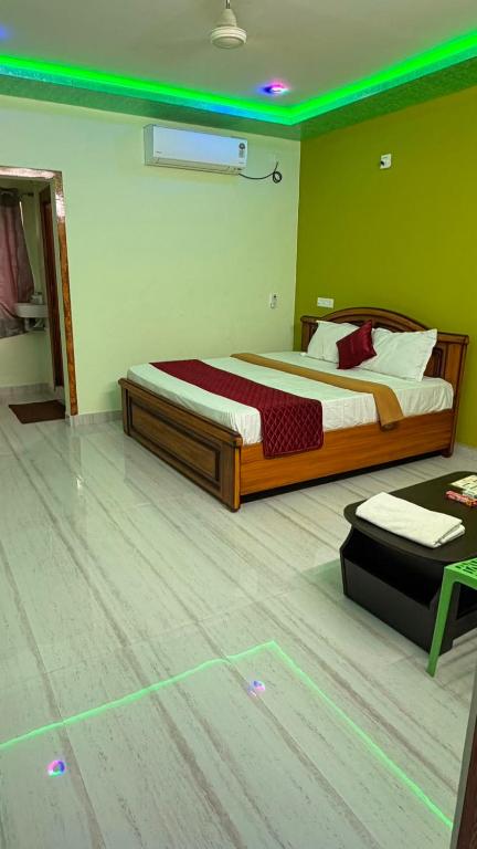 a bedroom with a bed with green lights on the floor at pnrpalace in Bāpatla