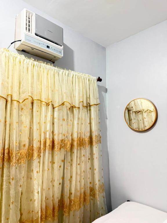 a bedroom with a curtain and a heater at Amori Spaces - MRG in Maribago