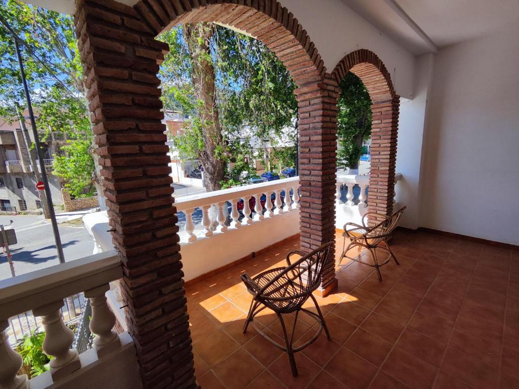 a room with two chairs and a balcony at Casa de los Yayos in Vélez de Benaudalla