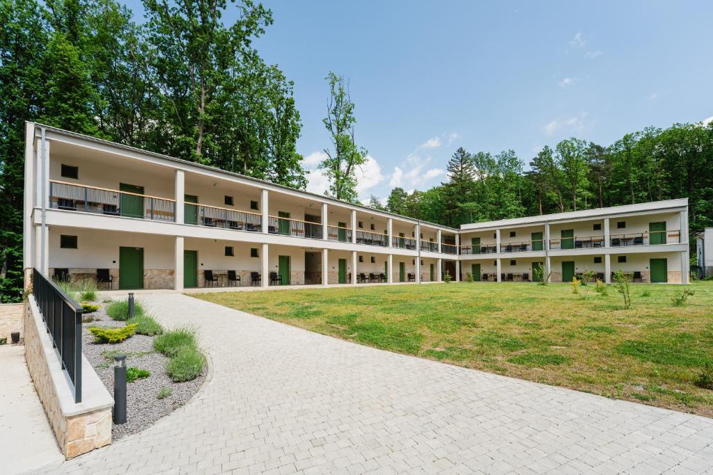 an exterior view of a large building with a park at PÚŠŤ rekreačné stredisko in Prievidza