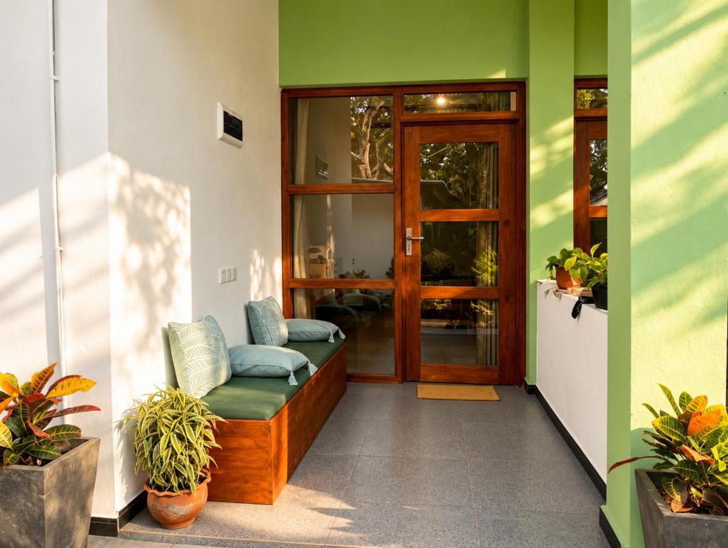 a porch with a bench in front of a door at Eagle Resort Arugambay in Arugam Bay