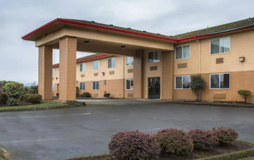 a hotel with a parking lot in front of it at Bridgeway Inn & Suites in Sublimity