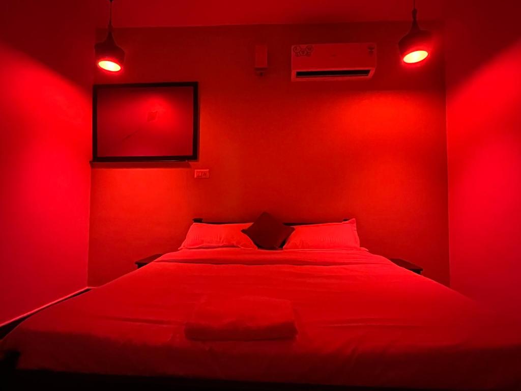 a red bedroom with a bed with red lights at Coliveinn in Ernakulam
