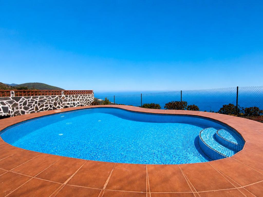 a swimming pool with the ocean in the background at Tomasín in Puntallana