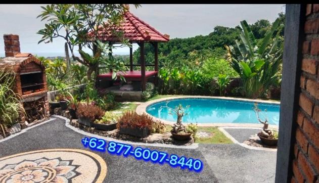 a swimming pool in a yard with a gazebo at Villa WENHOMANN View in Lovina
