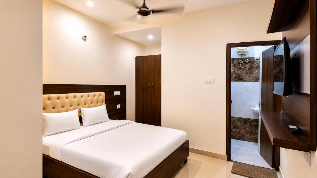 a bedroom with a bed and a tv and a bathroom at Hotel Red Hut Chandigarh railway station in Zirakpur