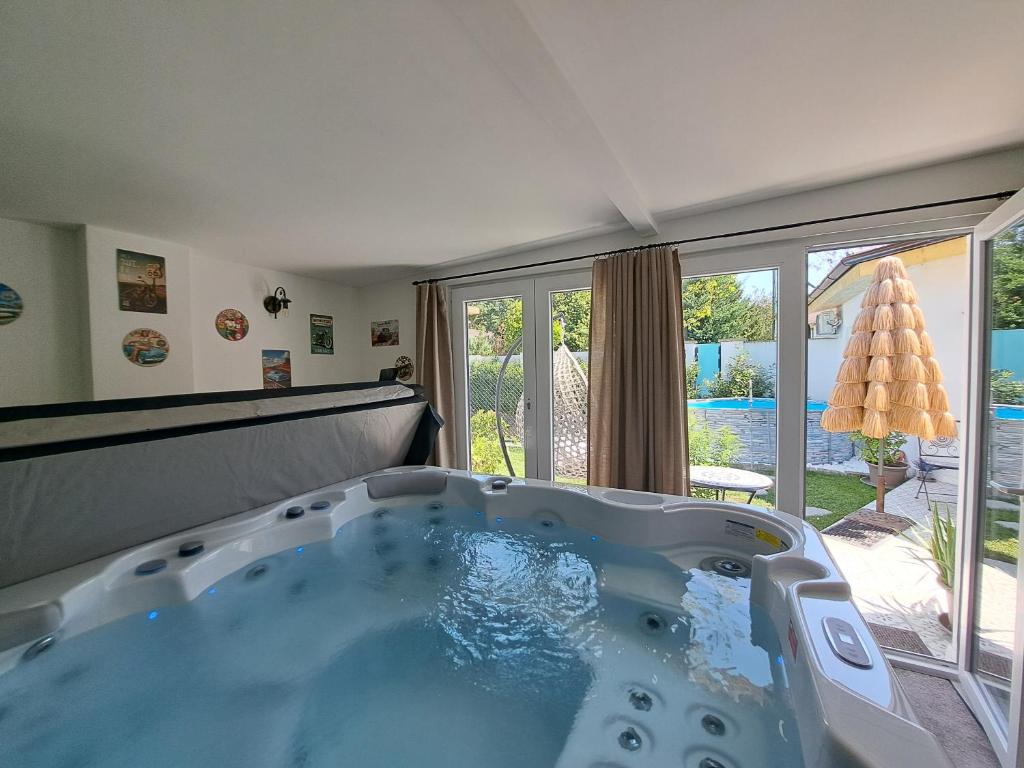 a large bath tub in a room with a large window at Kúria Apartman Extra in Budapest