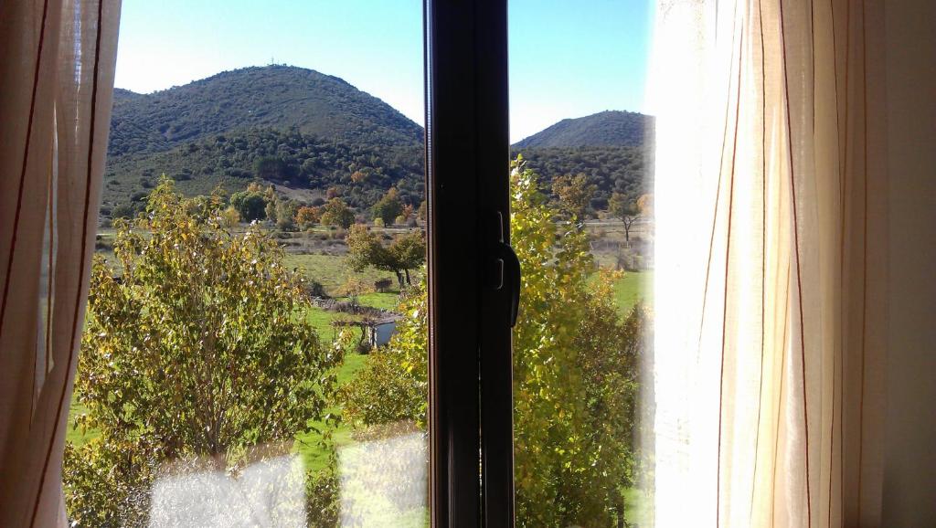 a window with a view of a mountain at Casa de dos habitaciones con piscina en Cabañeros in Navas de Estena