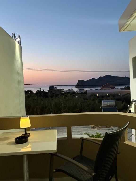 a table and chairs on a balcony with a view of the ocean at Suva Apartments Chania in Agia Marina Nea Kydonias