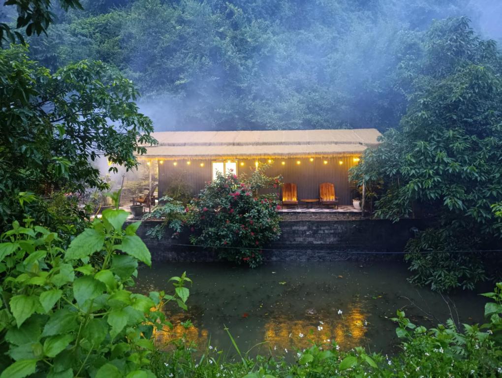 a house with a pond in front of it at Haven Kitchen & Cafe in Nguyễn Thôn