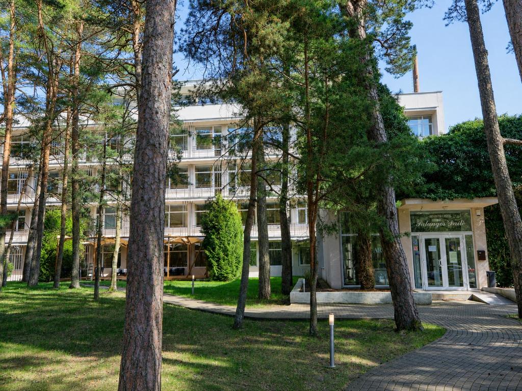 a building with trees in front of it at Palangos Dailė in Palanga