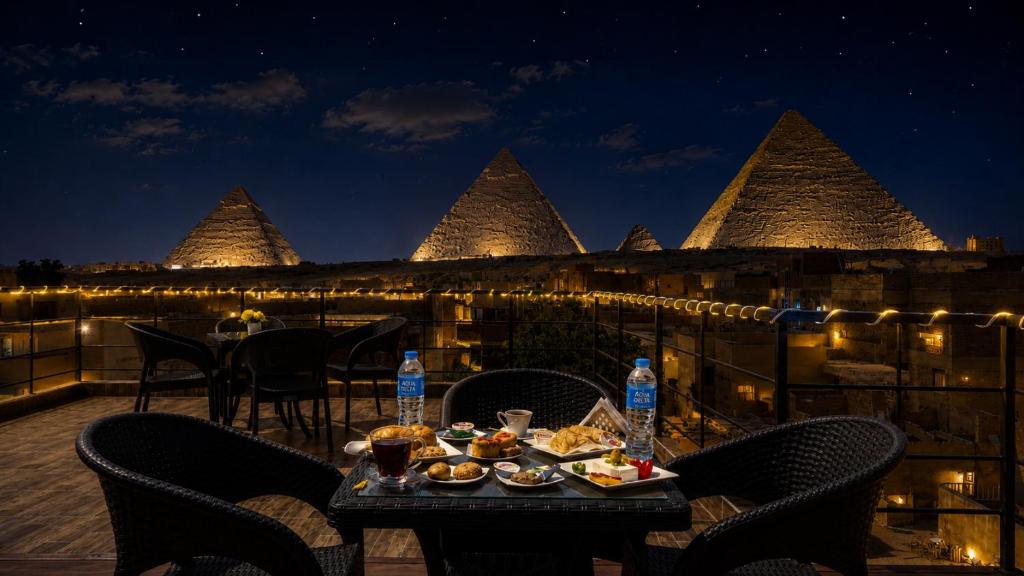 a table with food on a balcony at night at Pyramids Front Gate Hotel in Cairo