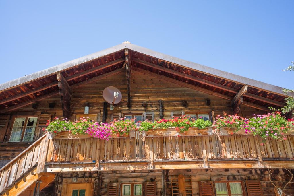 a wooden house with flower boxes on the balcony at Cosy Chalet in Brig-Glis in Glis