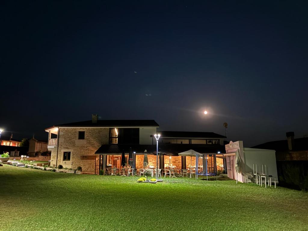 a house at night with a green field in front at A Casa do Pillado in Golada