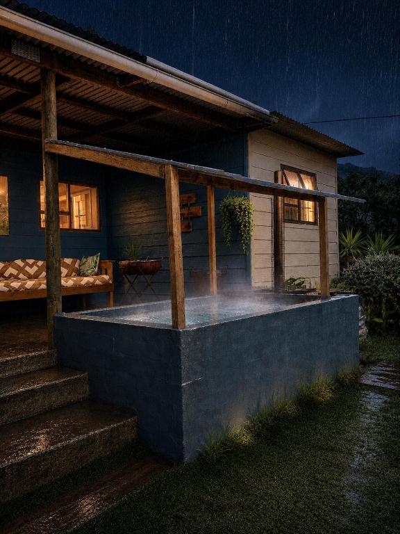 a house with a porch at night at 11 Mountain Stream Hot Tub Self Catering in Gordonʼs Bay
