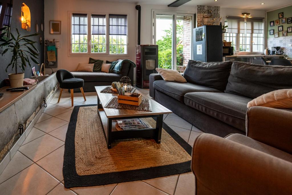 a living room with couches and a coffee table at Gîte Cosy Green avec Jardin, espace vintage et jeux de société in Chevincourt