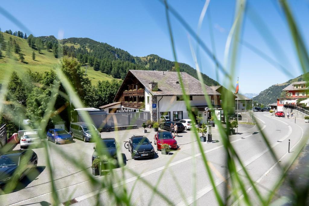 Eine Gruppe von Autos parkte vor einem Gebäude in der Unterkunft Hotel Galina Self-Check-in in Malbun