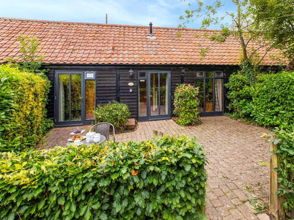 a house with a dog sitting in front of it at Thyme - E4485 in Catfield
