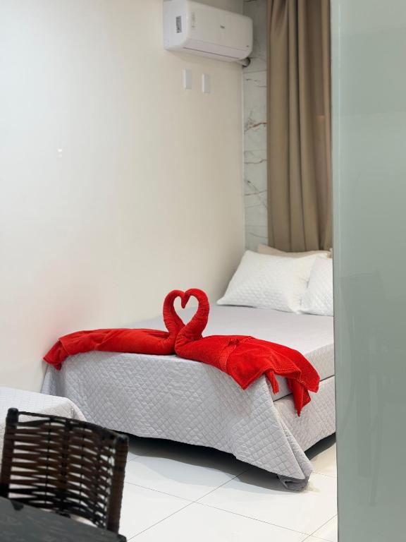 a bedroom with two beds with red blankets at Pacheco Pousada in Sabará