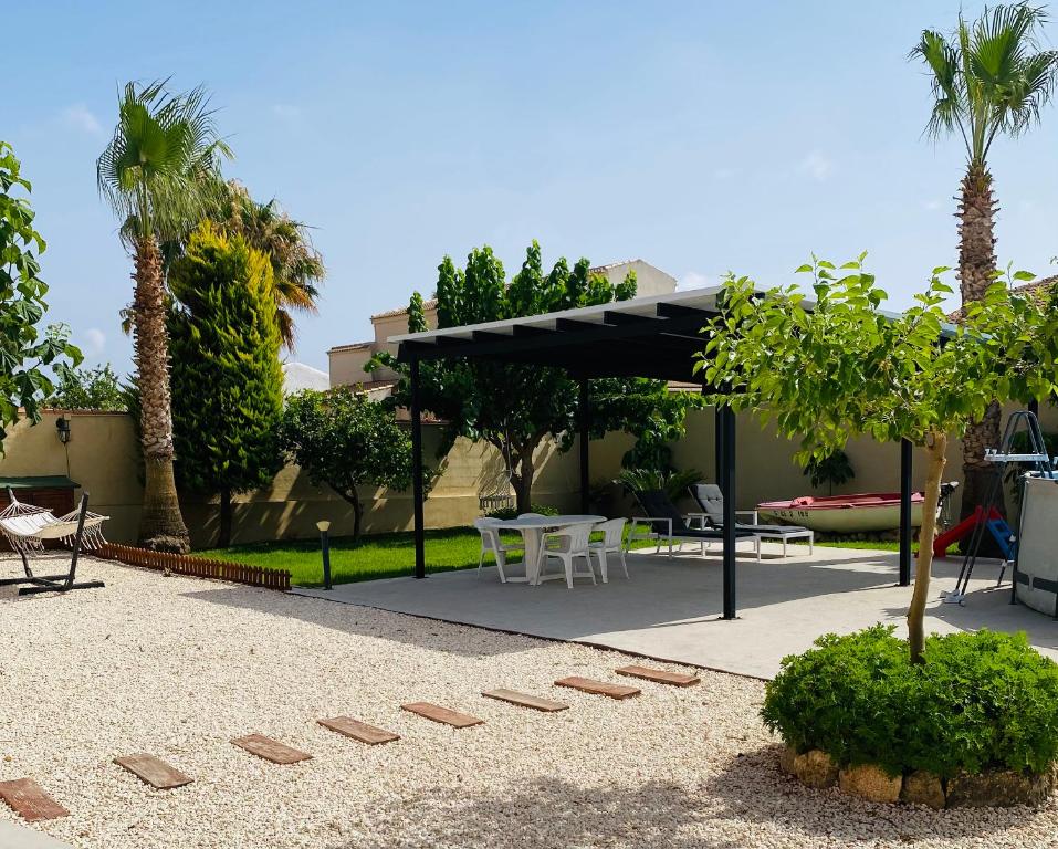 a pavilion with a table and chairs and palm trees at Laguna del Flamenco in Torrevieja