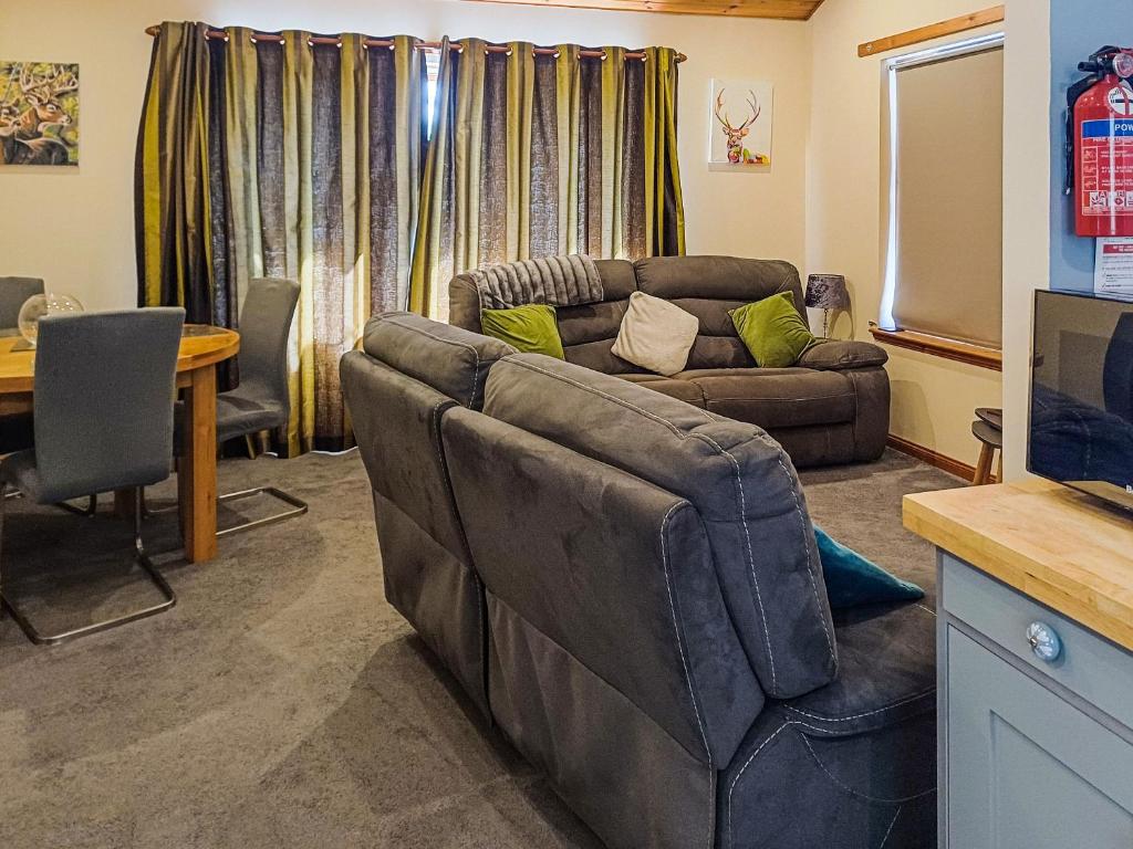 a living room with a couch and a table at Park Lodge in Strachan