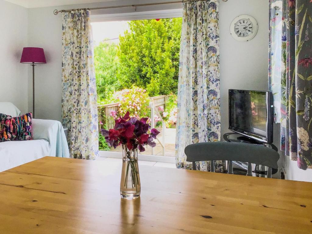 a vase of flowers sitting on a table in front of a window at Sweet Briar - 8234 in Bridport