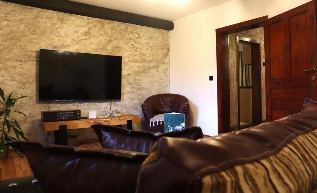 a living room with a couch and a flat screen tv at FoRest Apartment in Mokra Gora