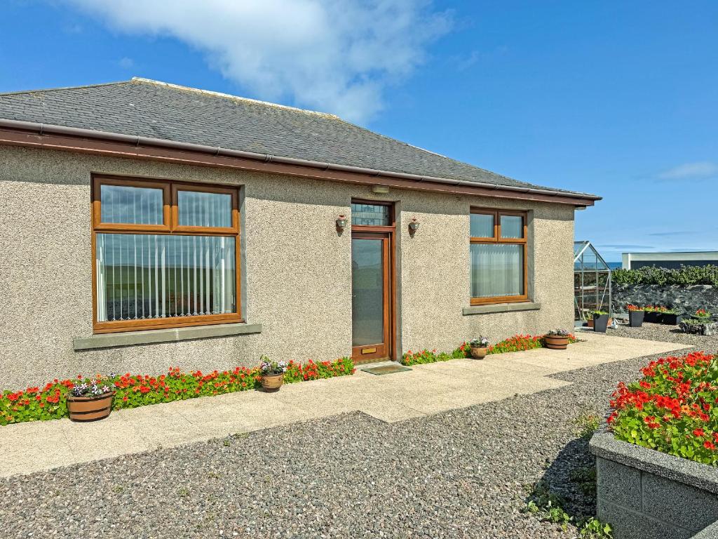 a house with flowers in front of it at Maple Cottage in Inverallochy