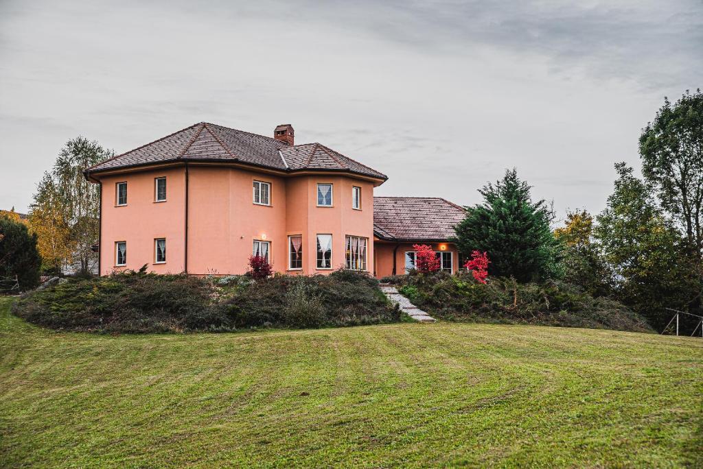 a large house on top of a grass field at Hide Away in a Private Countryside Villa in Prestranek