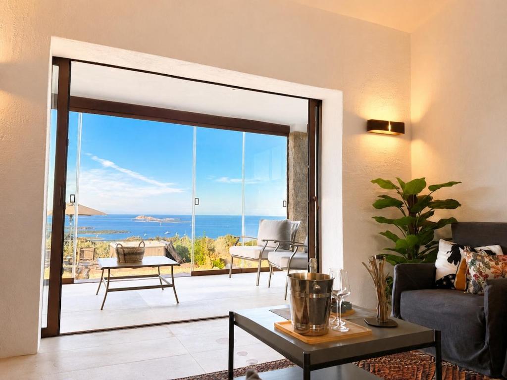 a living room with a sliding glass door to a patio at Villa Ottavio Costa Smeralda View 360 in San Pantaleo
