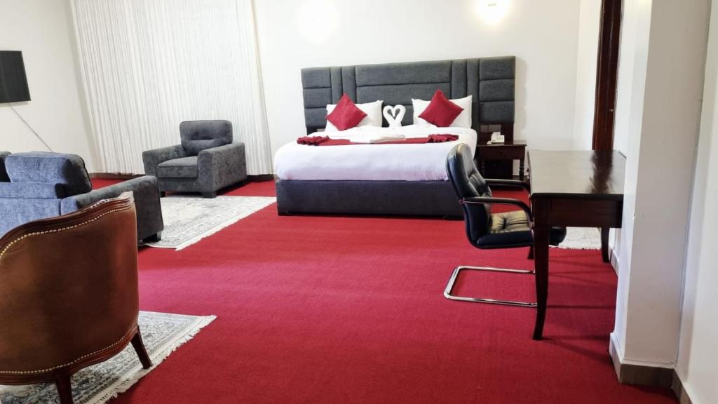 a hotel room with a bed and a desk and chairs at GRANADA HOTEL NAIROBi in Nairobi