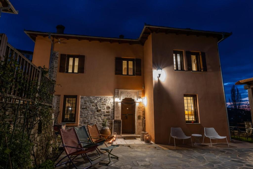 a house with chairs in front of it at night at Kalderimi Country House in Mouresi