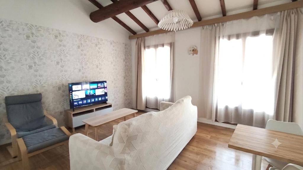 a living room with a couch and a tv and a chair at Bonlogem - Air-conditioned apartment Sainte Claire in Pertuis