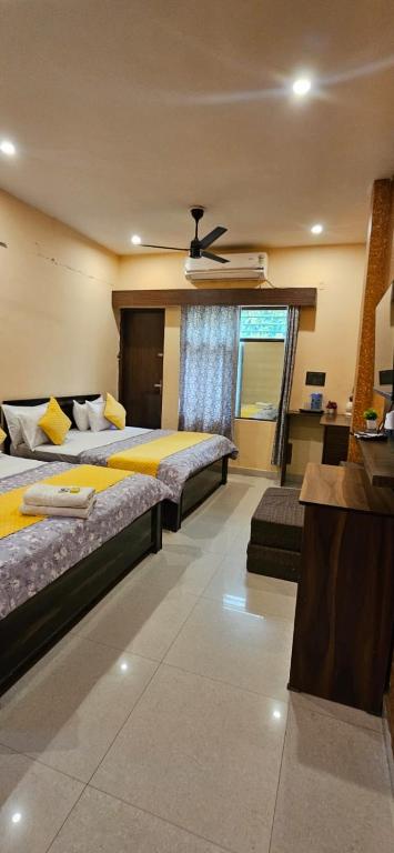 a bedroom with two beds and a ceiling fan at Krishna's land Homestay in Vrindāvan