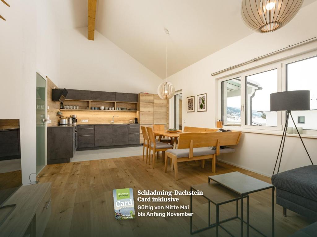a living room with a table and a kitchen at The Nest in Aich by Schladming-Appartements in Aich