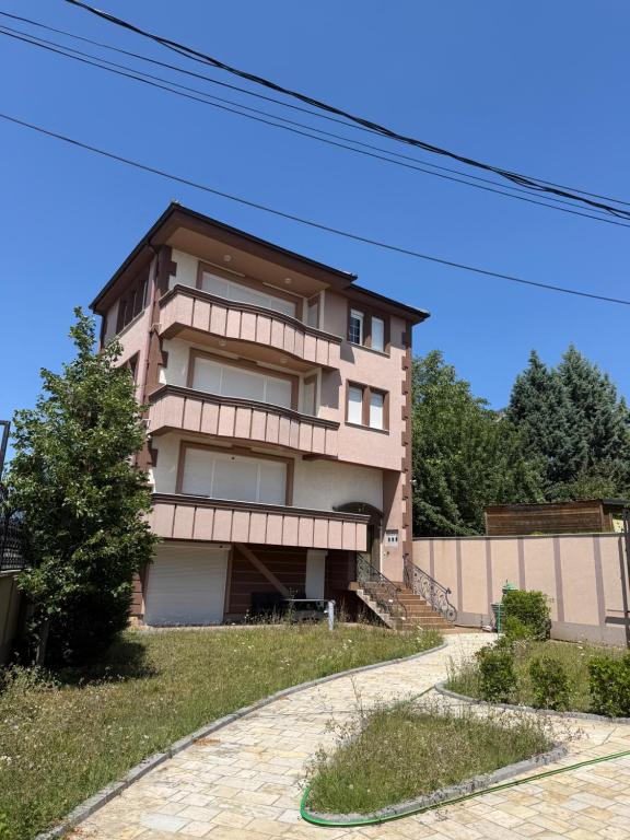 a tall building with a walkway in front of it at Prishtina Luxury House in Laplje Selo