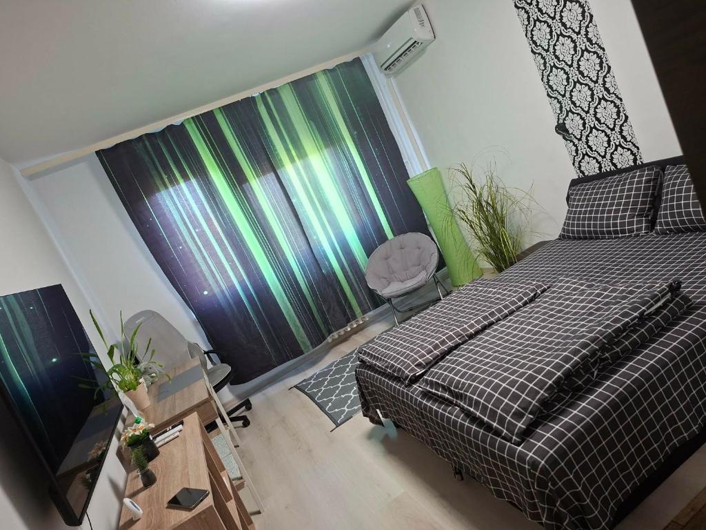 a bedroom with a bed and a window with a curtain at Zöld otthon in Szeged
