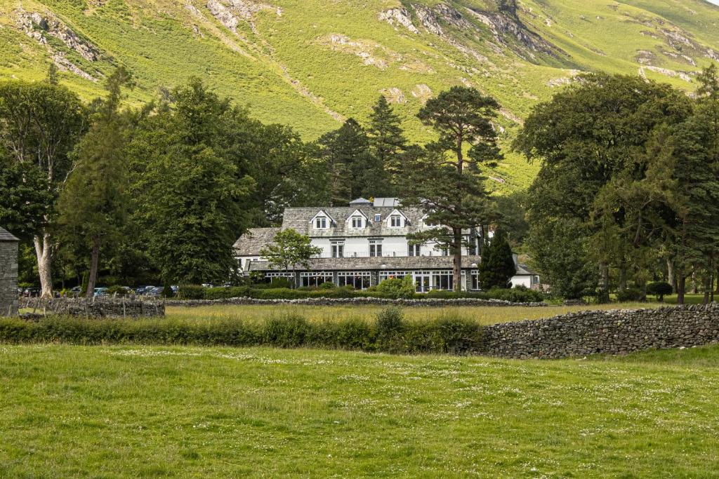 ein großes weißes Haus vor einem Berg in der Unterkunft Borrowdale Gates Hotel in Keswick