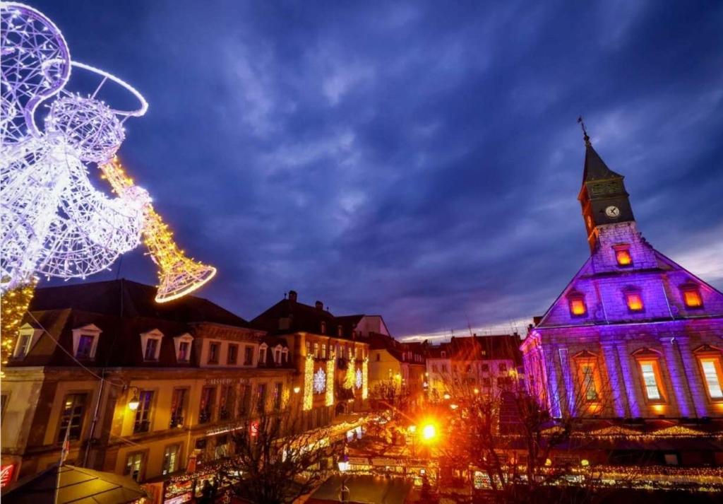 a building decorated with christmas lights in a city at Chez Alice 2 in Montbéliard