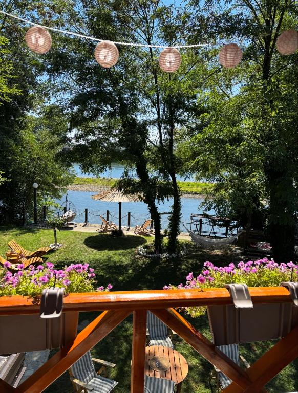 a balcony with flowers and a view of a lake at Drinski kej in Zvornik