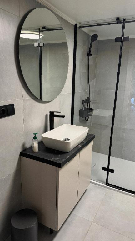 a bathroom with a sink and a mirror and a shower at Hi Wisła in Wisła