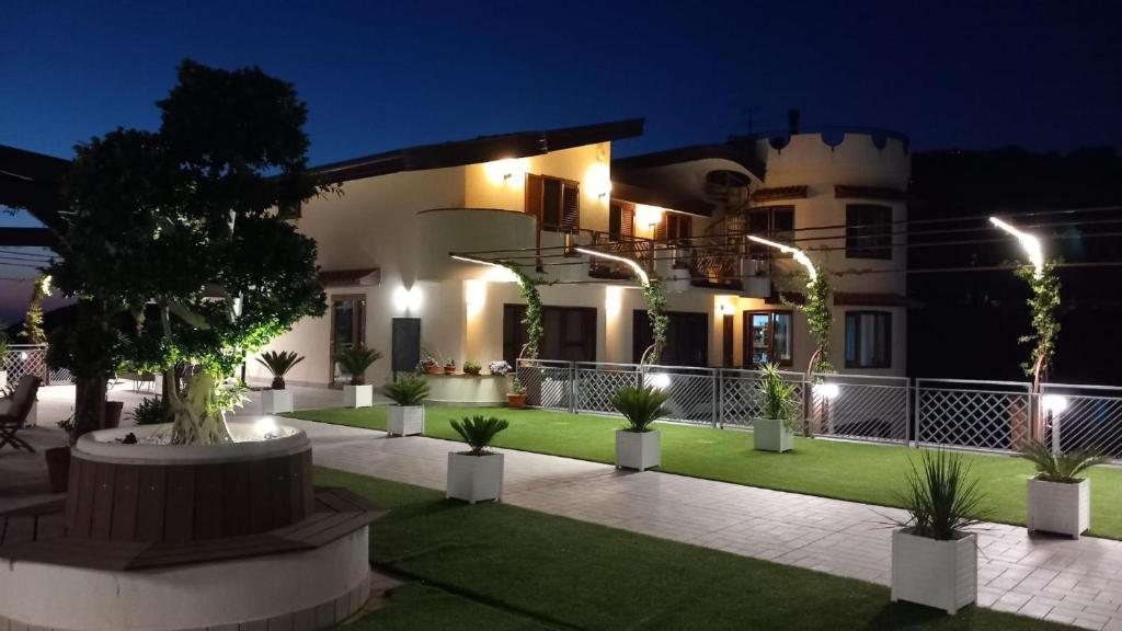 Ein Haus mit einem Innenhof, der mit Topfpflanzen und Lichtern geschmückt ist in der Unterkunft Sunshine Apartment in Pimonte