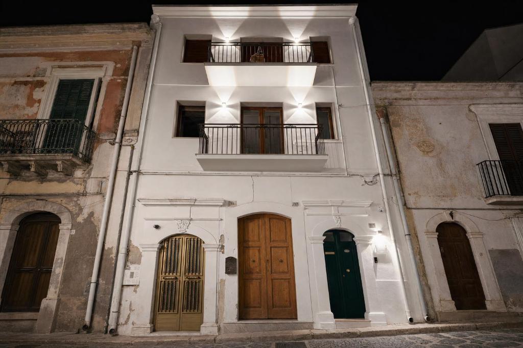 a white building with two doors and a balcony at Domus dell'Angelo in Monte SantʼAngelo