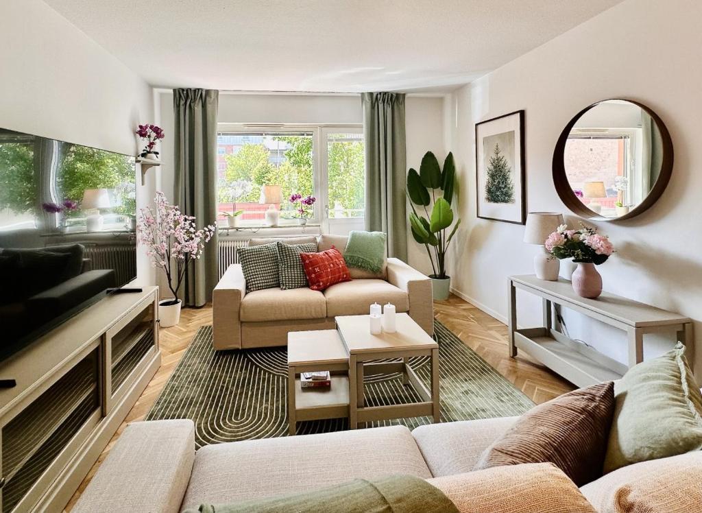 a living room with two couches and a mirror at Prinshöjden Apartments - Katrineholm Central in Katrineholm