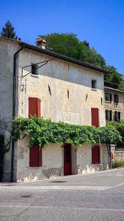a building with red doors and green ivy on it at B&b ANTICO MAGLIO in Asolo