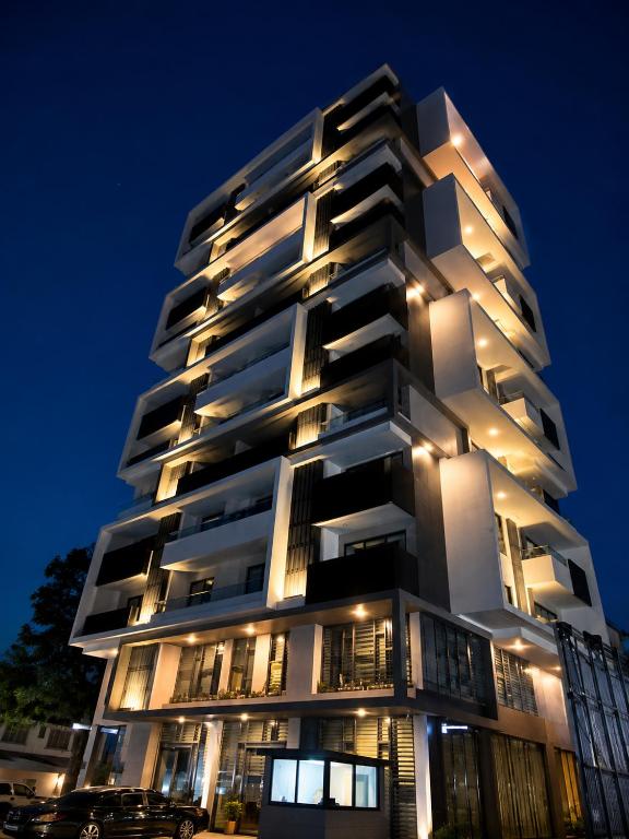 a tall white apartment building at night at Sky View Condo at Solaris in Christiansborg